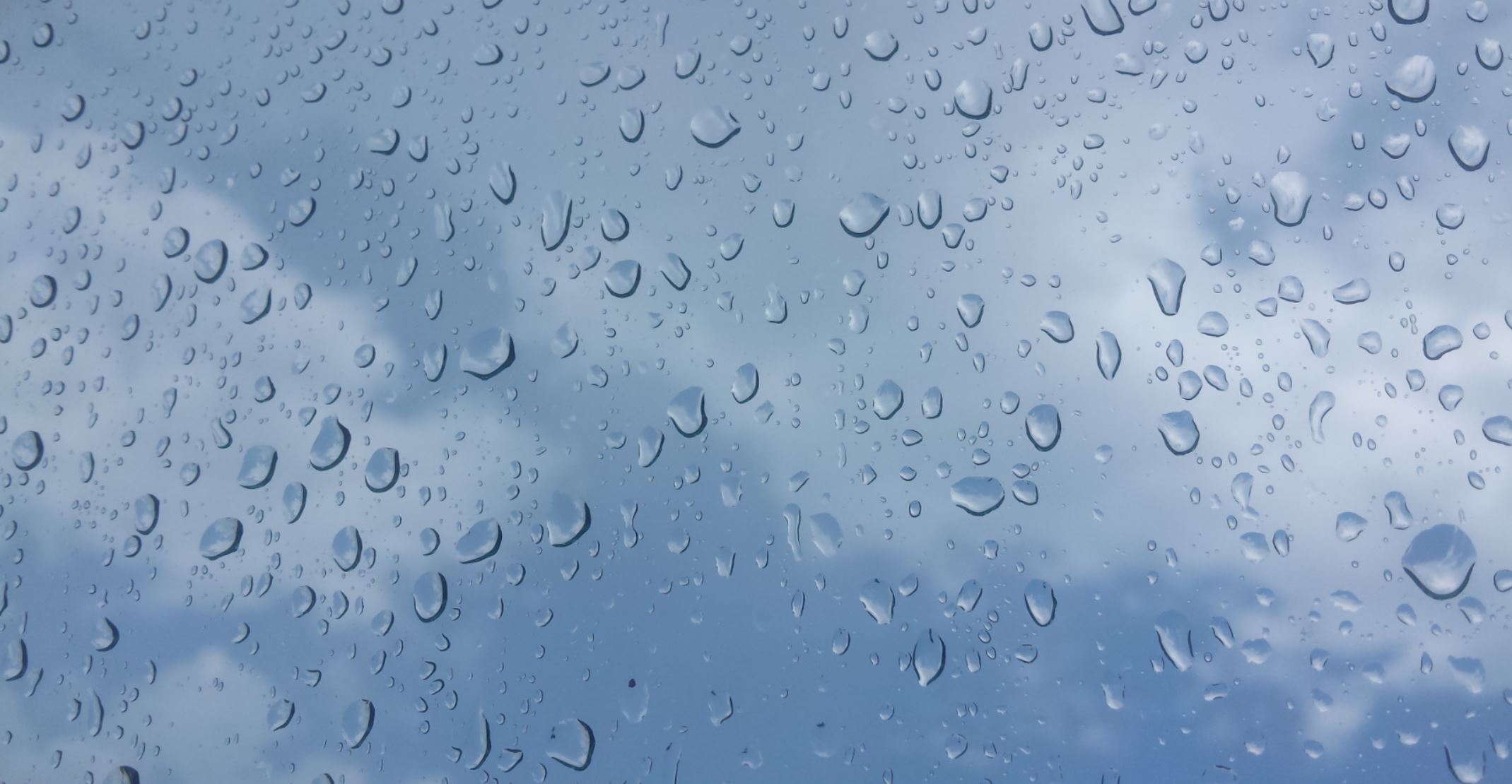 drops of rain on a window looking up at the sky